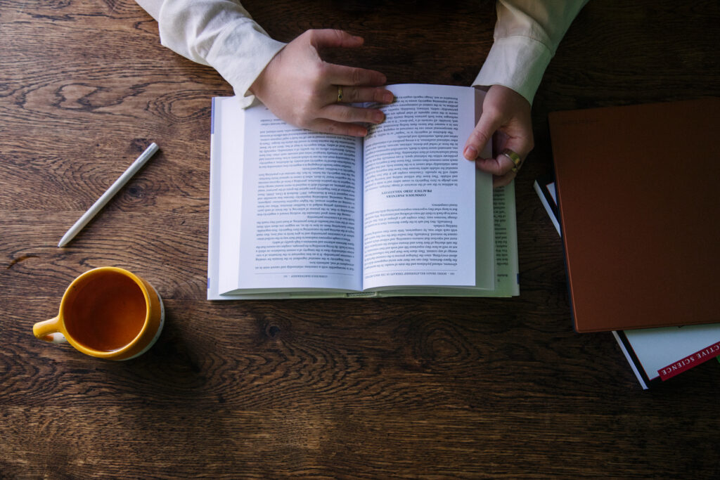 Open boek met een kop koffie op een houten tafel